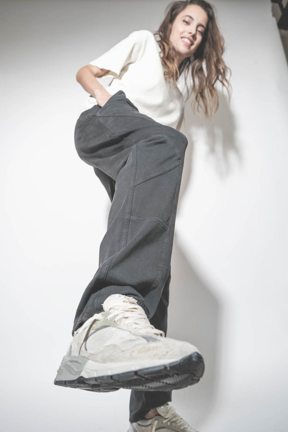 Baskets Running Dad blanche étoile en cuir lisse blanc Golden Goose femme.  Porté avec un bas de jogging noir.