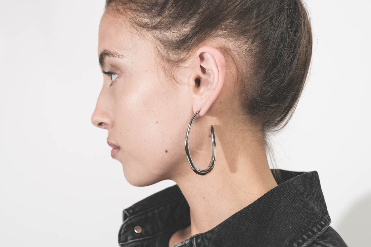 Boucles d'oreilles créoles en métal argenté Pleasant Isabel Marant Bijoux. Porté de profil.