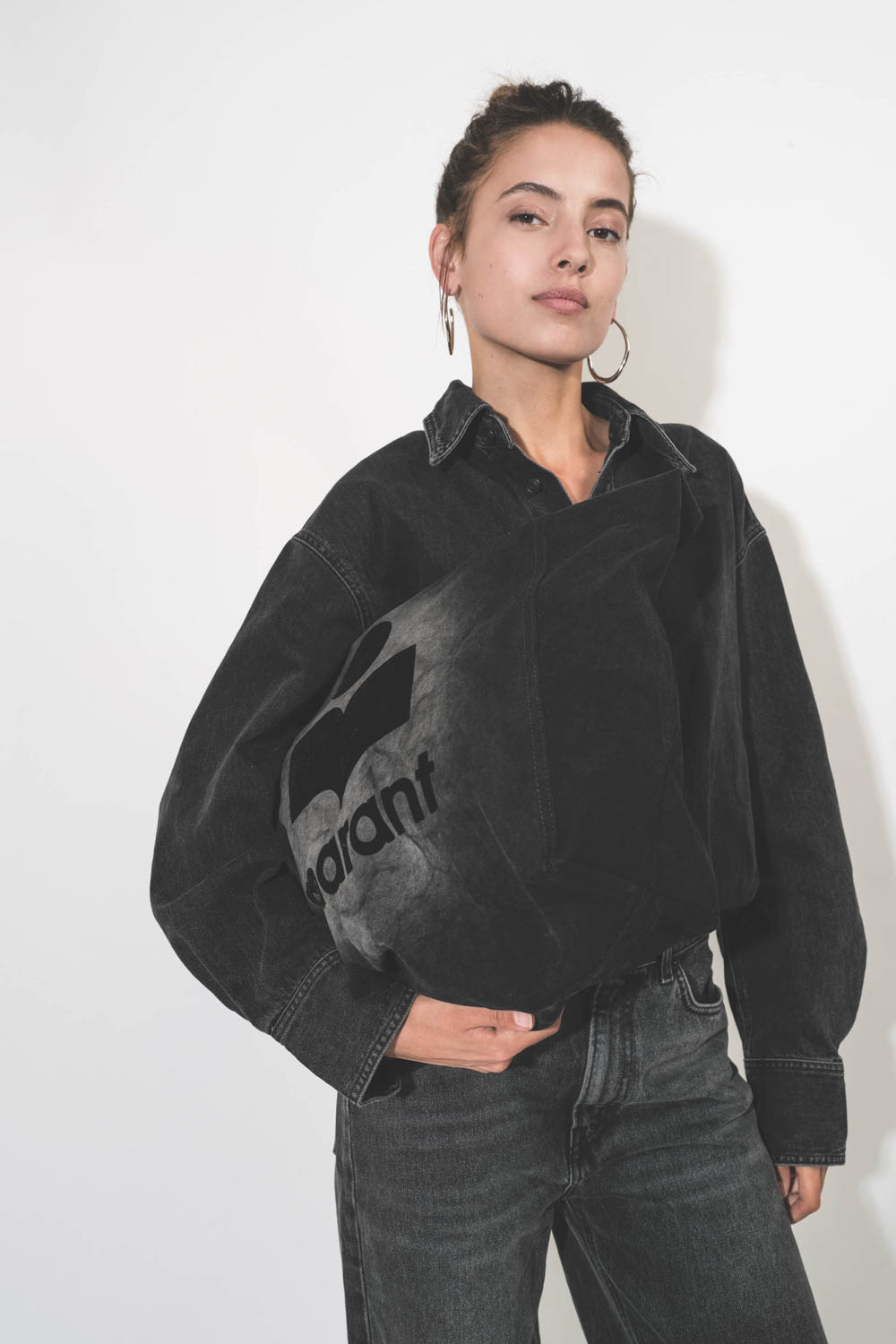 Boucles d'oreilles créoles en métal argenté Pleasant Isabel Marant Bijoux. Porté en total look noir.