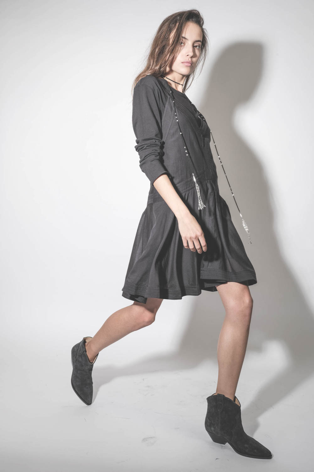 Boots en cuir suédé noir délavé Dewina Isabel Marant. Porté de profil avec une robe noire.