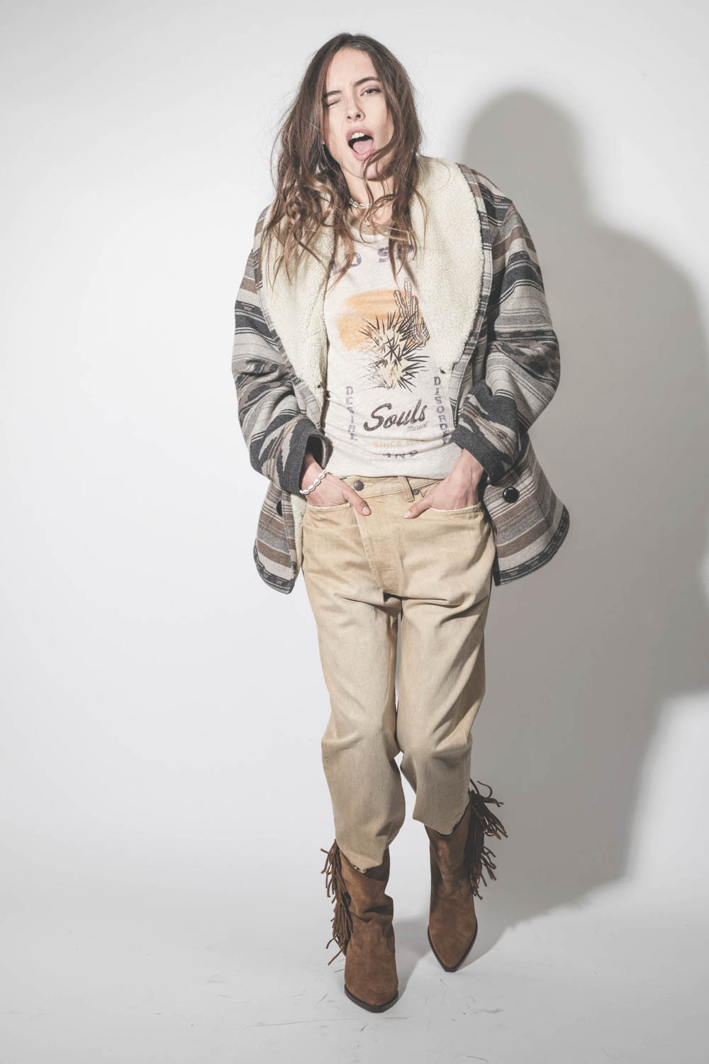 Manteau col châle fausse fourrure en laine motifs graphiques beige et écru Dorcas Marant Etoile. Porté sur un tee-shirt imprimé. 