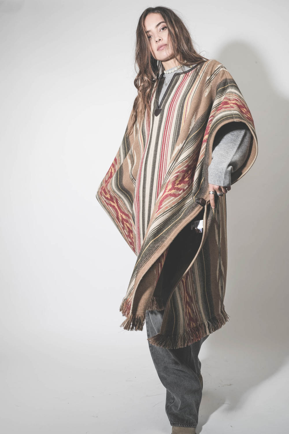 Poncho en laine mélangée à rayures beige écru Davida Marant Etoile. Porté sur un pull en cachemire gris.
