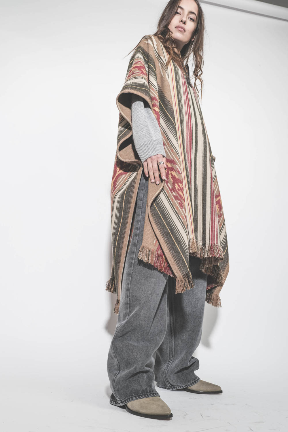 Poncho en laine mélangée à rayures beige écru Davida Marant Etoile. Porté avec un jean large gris.