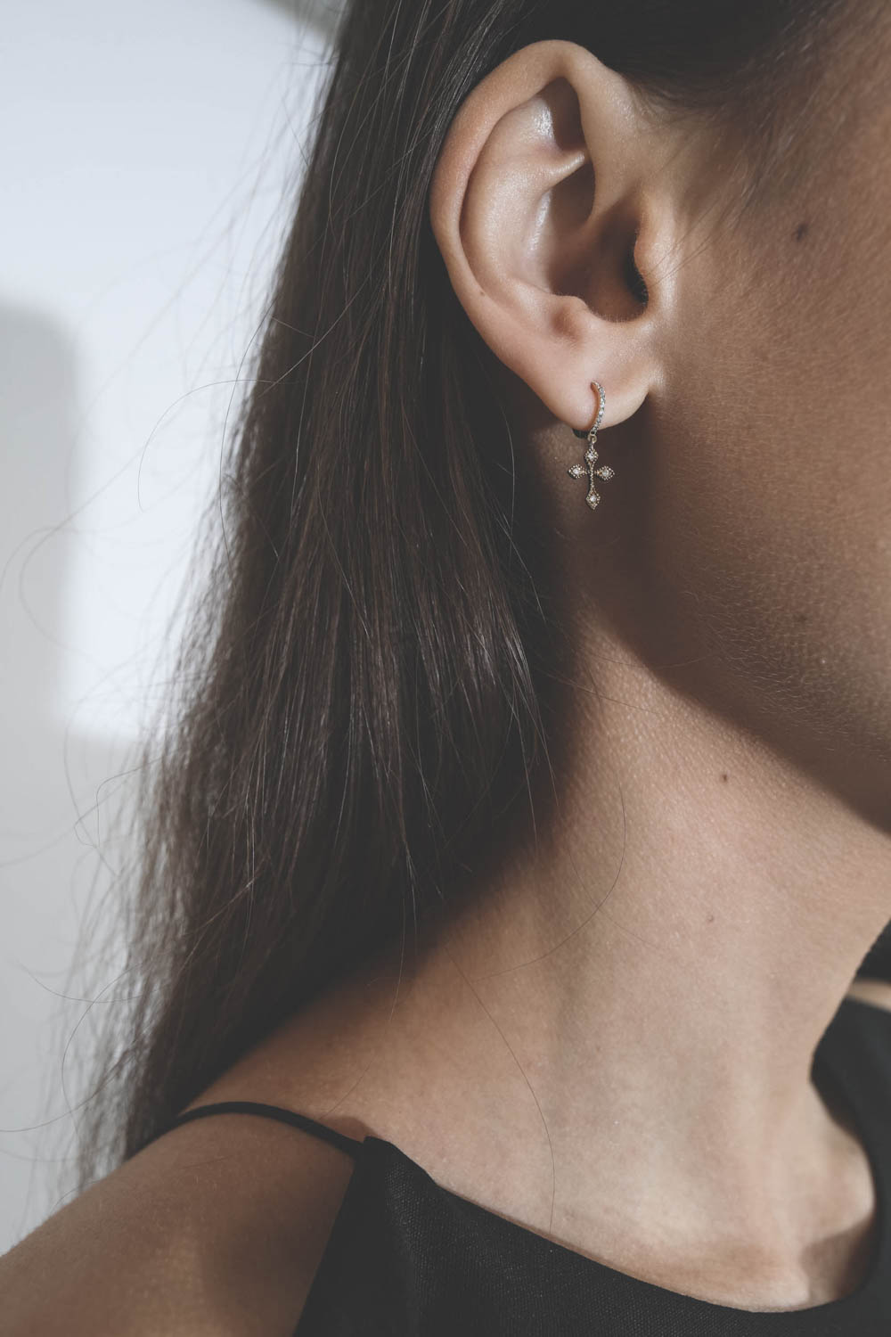 Mini créole en or jaune et diamants Baby Cross De Jaegher. Porté.