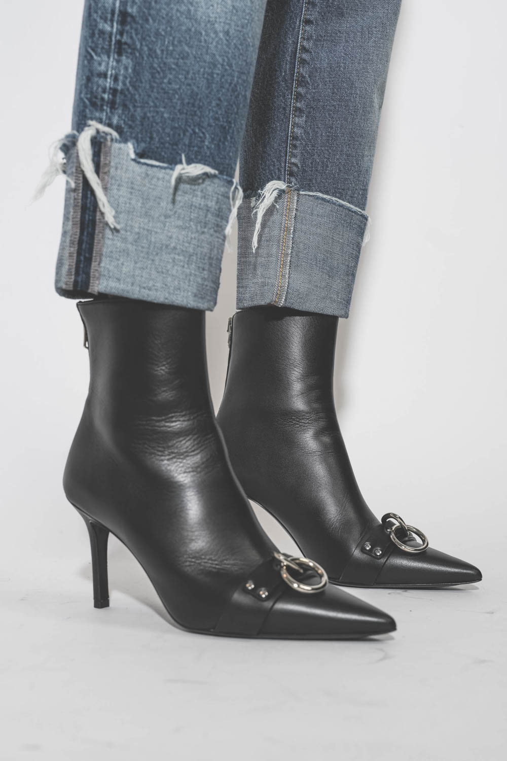 Boots à talons en cuir noir anneaux métal argenté Sid Heeled Harness Boots R13. Porté avec un jean Baggy à revers bord franc.