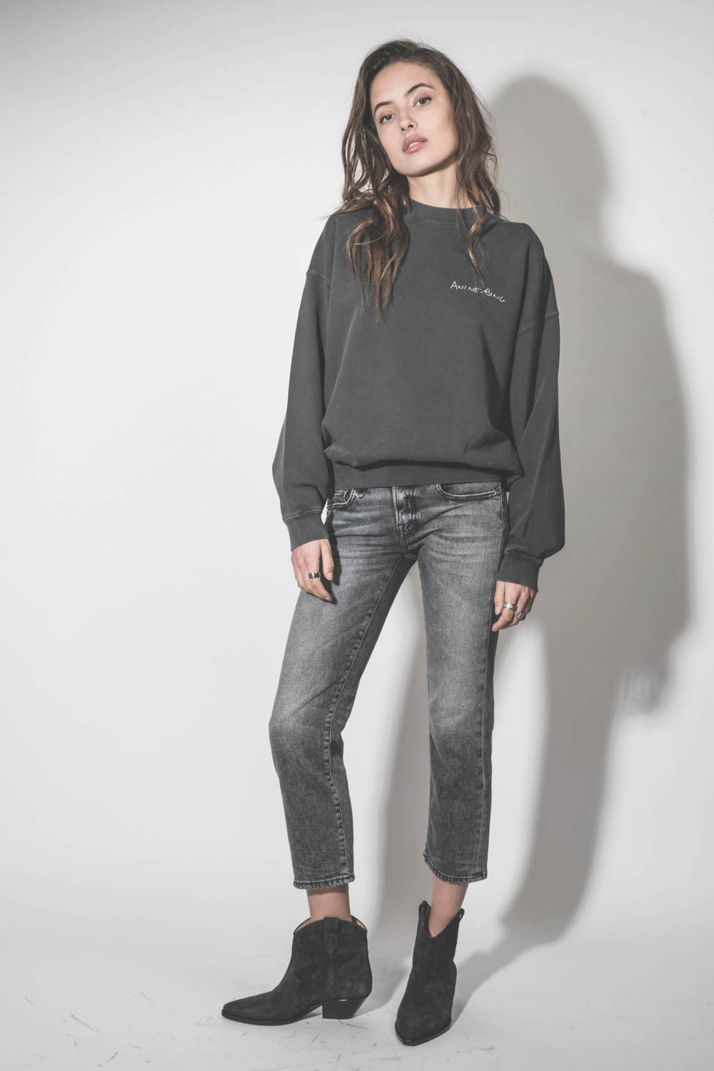 Jean taille basse Skinny Boy Straight Vintage Grey R13 Denim. Porté avec des boots santiags noires en cuir suédé. 