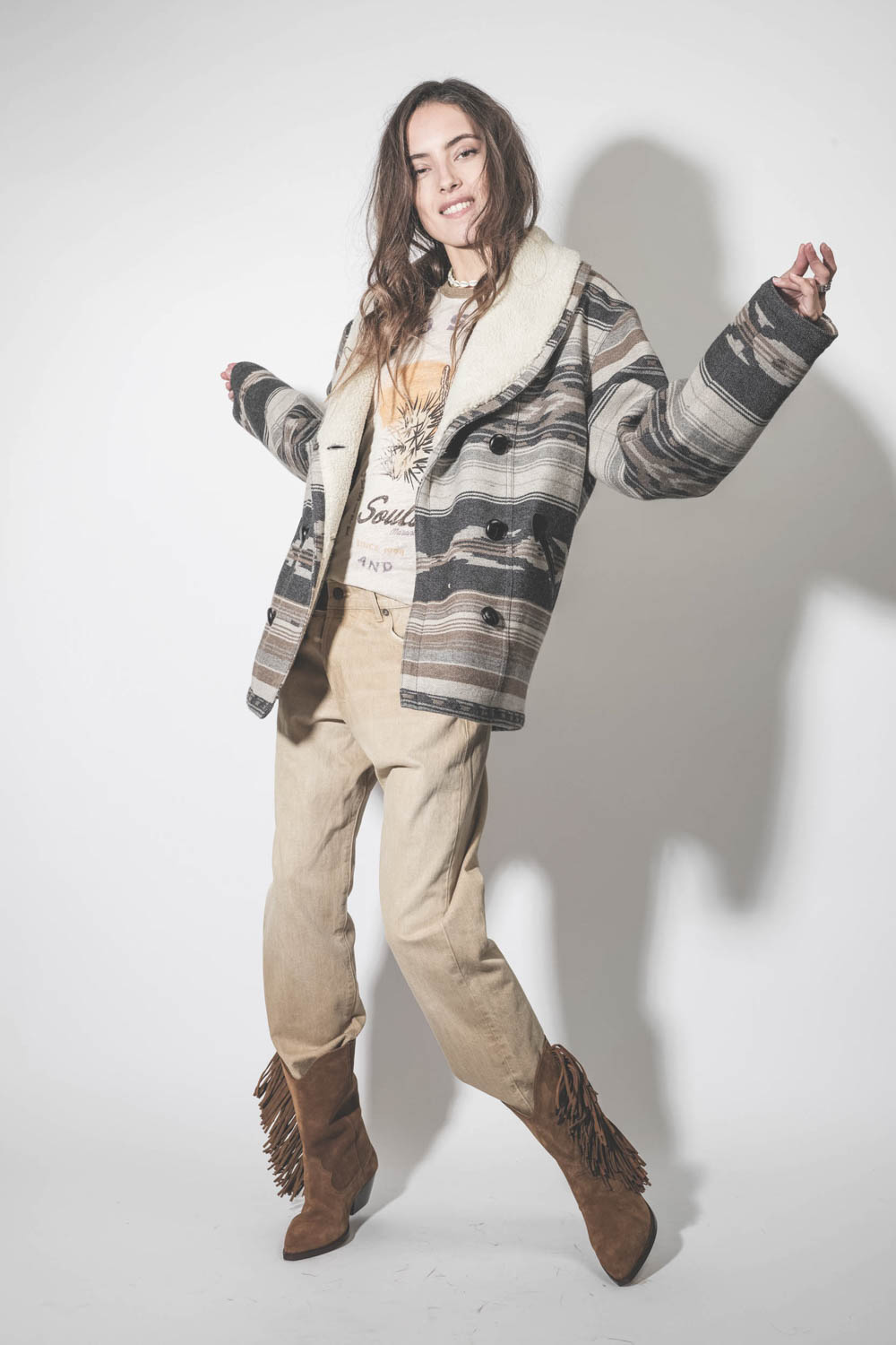 Jean large Crossover en toile beige clair délavage Faded Wheat R13. Porté avec des santiags à franges.