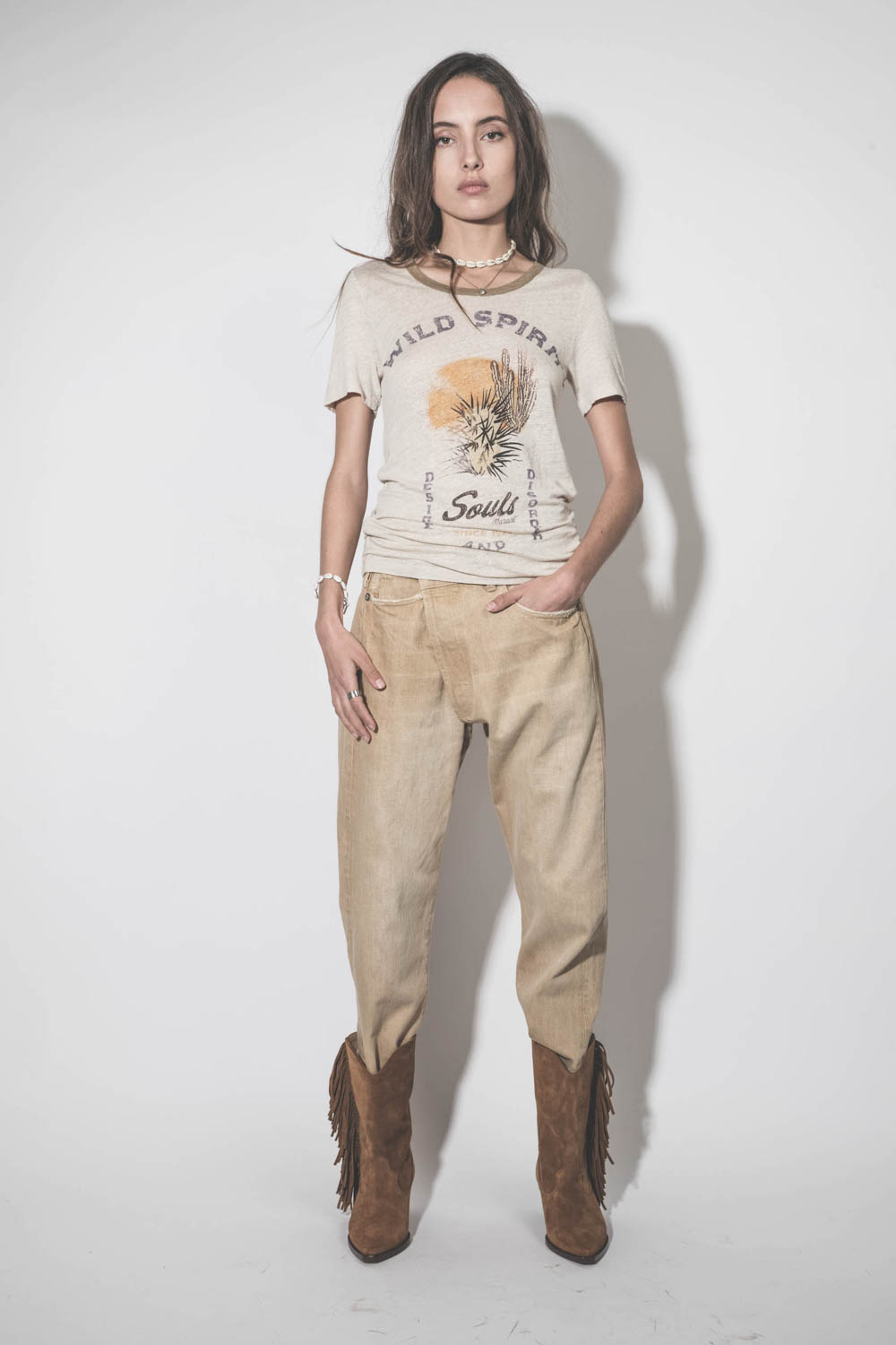 Jean large Crossover en toile beige clair délavage Faded Wheat R13. Porté de face avec un tee-shirt en lin écru imprimé.