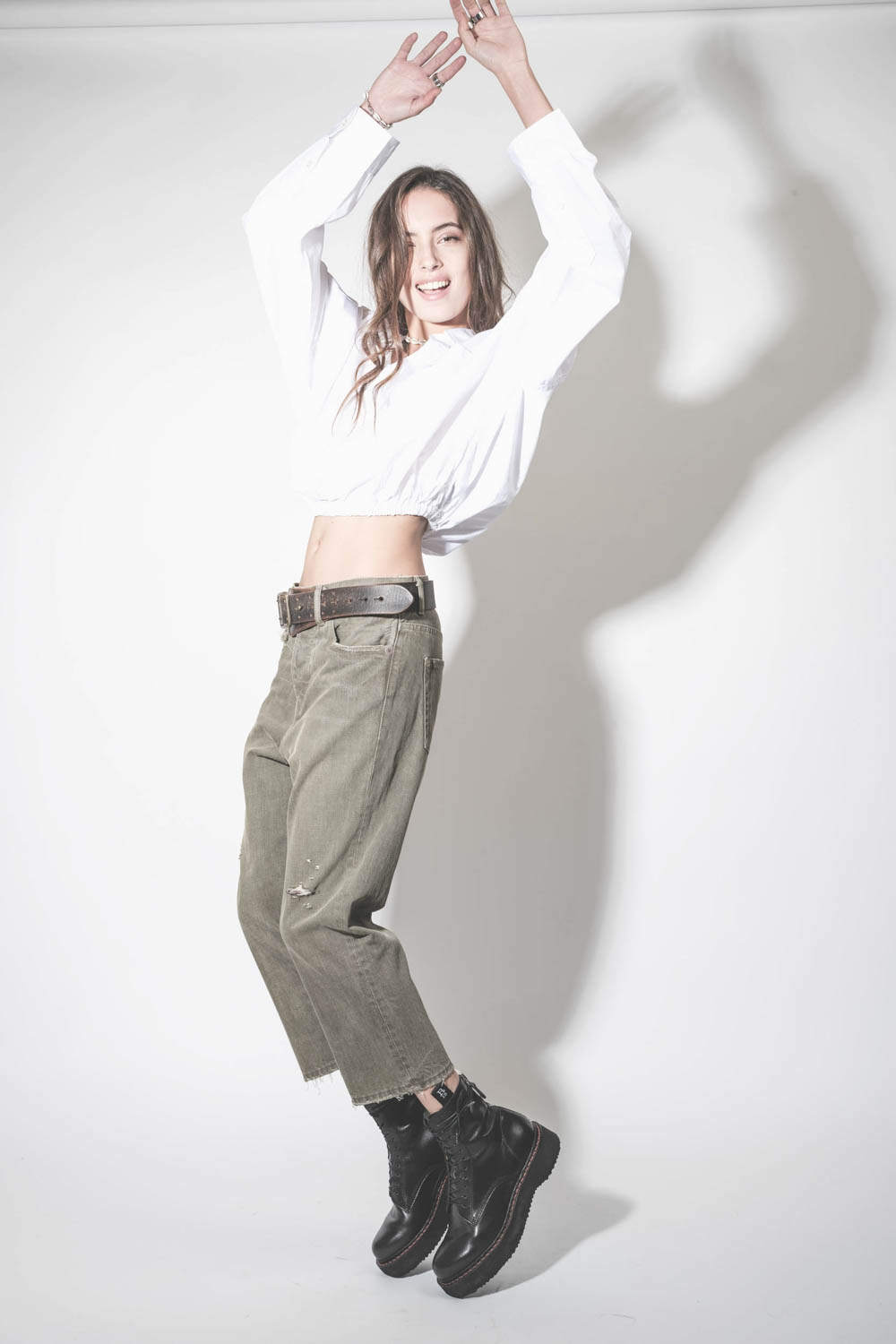 Jean baggy Tailored Drop toile kaki usée et déchirée R13 denim. Porté avec des boots à lacets en cuir noir.